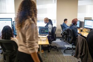 An office setting of people using computers.